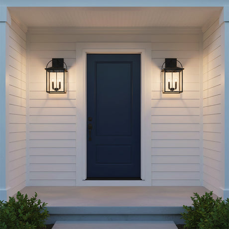 Darby Outdoor Wall Light, Medium 20" Black - Two black lanterns flanking a navy blue front under a porch.