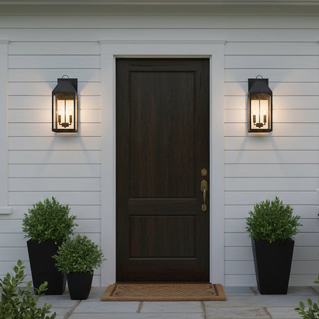 Chester Outdoor Wall Light, Medium 20" Black - Two black lantern-style lights flanking a dark wood front door.