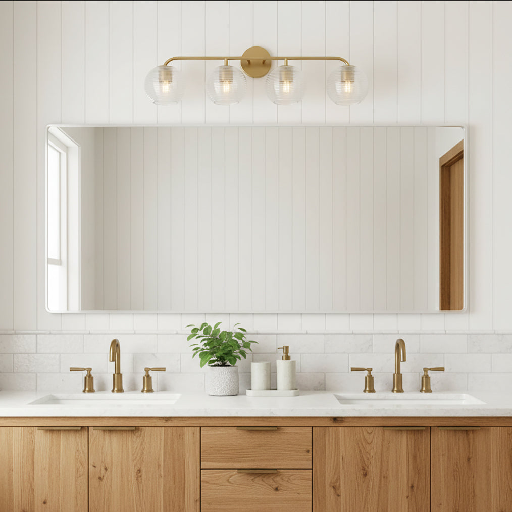 Ori 4 Light Vanity, Matte Brass - A bathroom vanity with a wood cabinet, white countertops, and a matte brass light fixture with four glass globes.