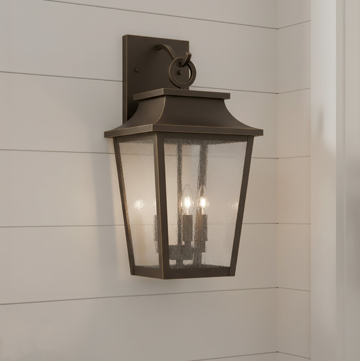 Bronze Beckett outdoor wall light fixture on a white wooden horizontal siding.