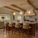 A transitional kitchen with three Ori Pendant 17" Matte Brass ribbed glass globes suspended over a white marble island under a beamed and shiplap ceiling.