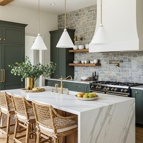 A farmhouse kitchen with three Avin Pendant 15", White and Aged Brass pendants over a white marble waterfall island with green cabinets and a stone backsplash.