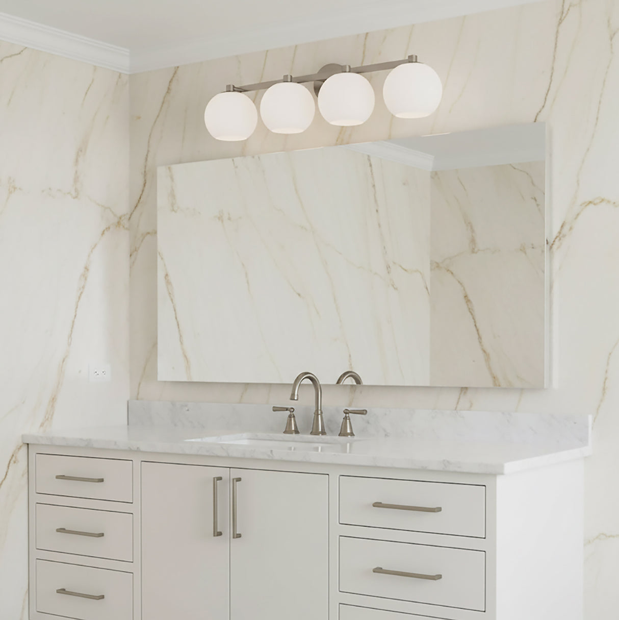 Enid 4 Light Vanity Light, in Brushed Nickel finish, shown above a wide frameless mirror in a bathroom with marble slab walls.