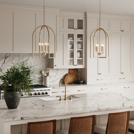 Modern kitchen with marble countertops, white cabinets, and two Elira Lantern Pendants in aged brass.