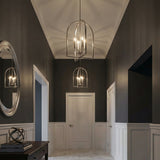 Brushed Nickel geometric pendant in a Transitional Entryway with a dark console table and oval mirror.
