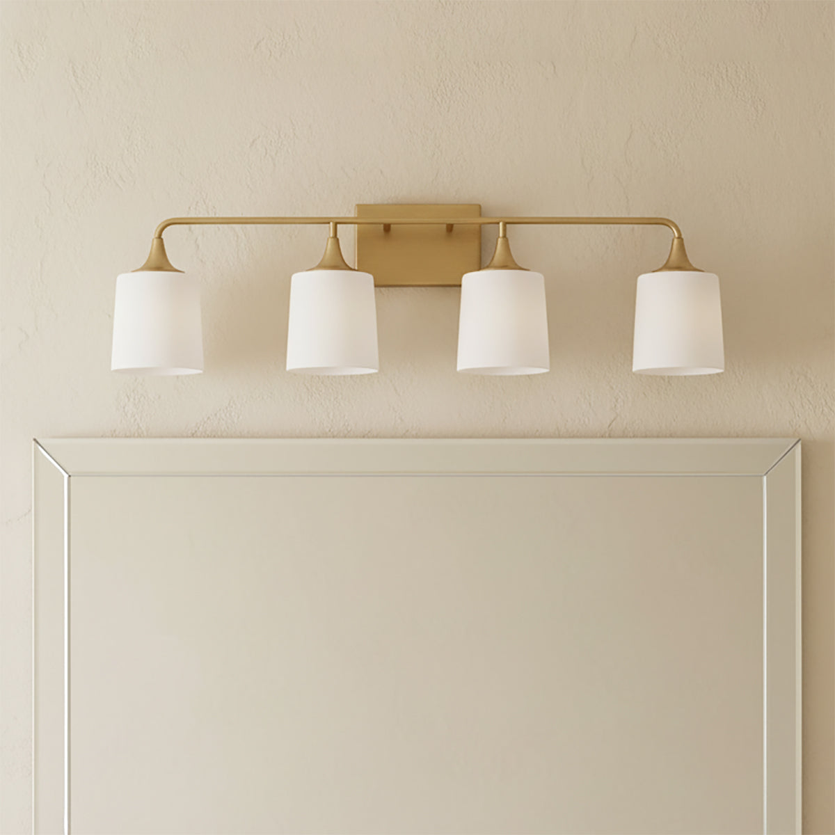 Harper 4 Light Vanity, Aged Brass - Vanity light fixture above a mirror in a bathroom setting.