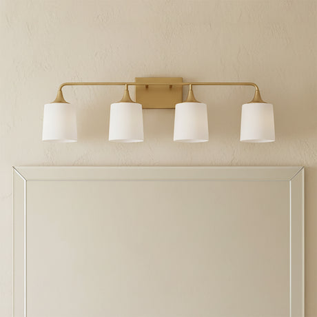 Harper 4 Light Vanity, Aged Brass - Vanity light fixture above a mirror in a bathroom setting.
