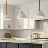 Sutton White and Aged Brass geometric pendant in a Transitional Kitchen with a white marble island and shaker cabinets.