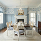 Eloise Lantern Pendant 28", Textured White geometric Pendant in a Coastal Dining Room with cane back chairs and blue floral wallpaper.