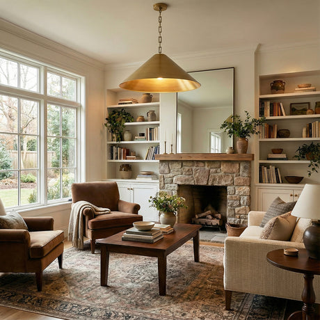 Aged Brass conical metal pendant in a Transitional Living Room with a stone fireplace and patterned rug.