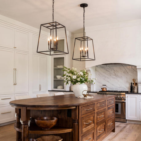 A modern farmhouse kitchen with two Tilden Lantern Pendants in textured black over a walnut wood island featuring white shaker cabinets and a marble slab backsplash.