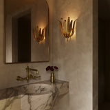 Luxurious bathroom interior with marble sink, gold fixtures, and the Cerise Wall Sconce in Antique Gold