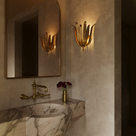 Luxurious bathroom interior with marble sink, gold fixtures, and the Cerise Wall Sconce in Antique Gold