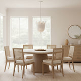 Cerise Pendant 16, Textured White - A white lotus-shaped pendant light hangs over a round dining table with cane-backed chairs.