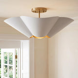 A contemporary foyer with a white and matte brass semi-flush mount along the ceiling near white crown molding and a paneled door frame leading outdoors.