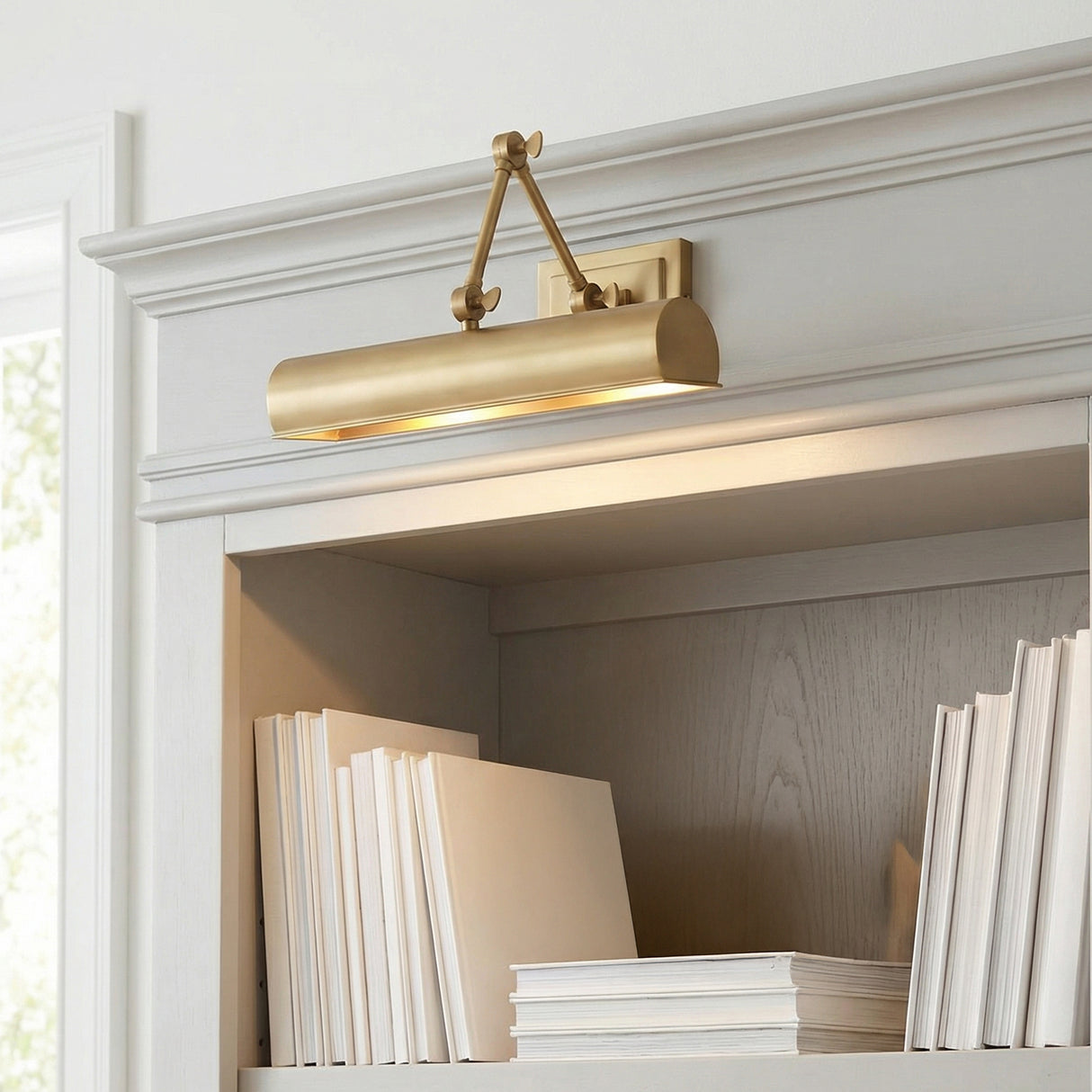 Henry Picture Light 16", Aged Brass linear Picture Light in a Transitional Living Room with a built-in bookshelf.