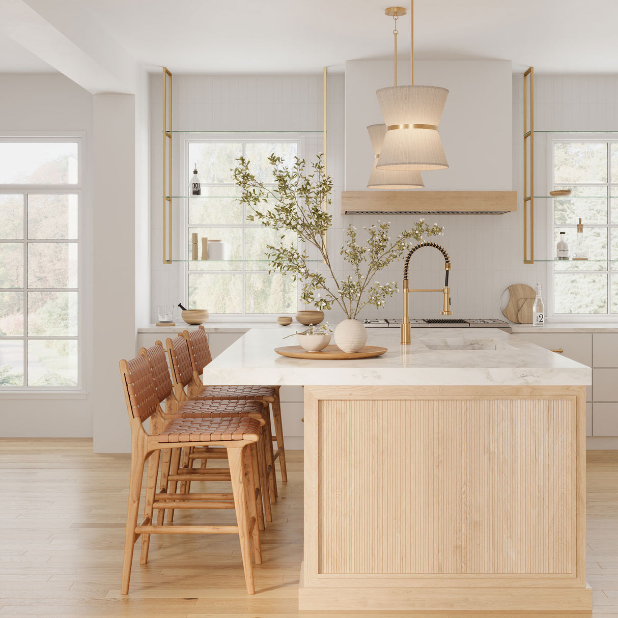 Two Beacon 12" wide pendants with natural rope and brass finish are hung above a kitchen island, with light wood tones and white stone countertop.