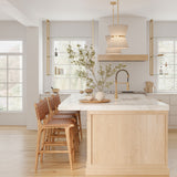 Two Beacon 12" wide pendants with natural rope and brass finish are hung above a kitchen island, with light wood tones and white stone countertop.