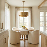 Reed Pendant 21", Textured Brushed Brass geometric pendant in a Transitional Dining Room with a light wood dining table and curved chairs.