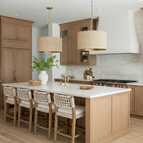 A transitional kitchen featuring two Leery Pendant 20", Whitewash and Matte Brass fixtures over the island with light wood cabinets and a white marble backsplash.