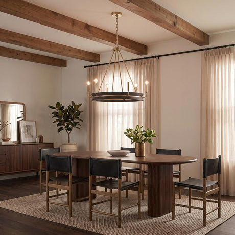 A modern farmhouse dining room featuring the Maren 6 Light Chandelier in ebony and matte brass over a walnut table under a beamed ceiling with beige curtains.