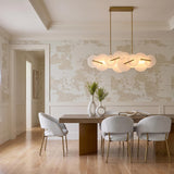 A transitional dining room with the Malya LED Linear Chandelier in brass and opal glass over a wood table under a coffered ceiling with wainscoting.