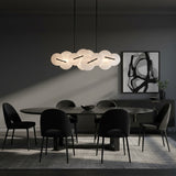 Malya LED Linear Chandelier 56, Matte Black with Opal Glass - A modern dining room with an oval marble table, black chairs, a dark sideboard with artwork and a modern chandelier.