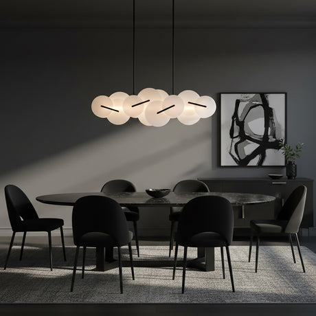 Malya LED Linear Chandelier 56, Matte Black with Opal Glass - A modern dining room with an oval marble table, black chairs, a dark sideboard with artwork and a modern chandelier.