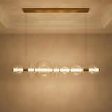 Elara LED 7 Light Linear Chandelier 56", Brass and Clear Glass for Modern home with Textured Beige Walls