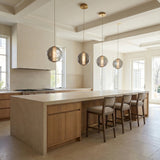 Elara LED Pendant 9", Brass and Smoke Glass globe pendant in a Transitional Kitchen with a light wood island and upholstered bar stools.