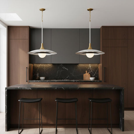 A contemporary kitchen features two Yates LED Pendant 30", Matte White fixtures with brass accents over a black marble waterfall island paired with dark wood cabinets.