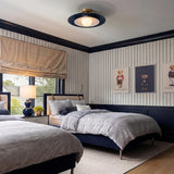 A traditional bedroom featuring the Yates LED Flush Mount 18", Matte Navy on the ceiling center above pinstripe wallpapered walls and twin herringbone beds.