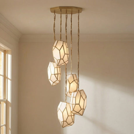 Antique Brass 5-light geometric chandelier in a Transitional Dining Room with subtle wall molding and natural light.
