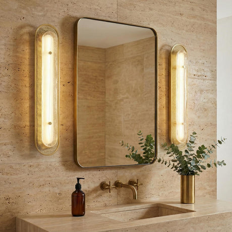 Vance LED Wall Sconce 30", Brass and Textured Glass styled in a Modern Bathroom with travertine tile.