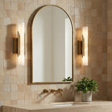 Delya LED Wall Sconce 16", Antique Brass and Alabaster styled in a Modern Bathroom with textured tile.