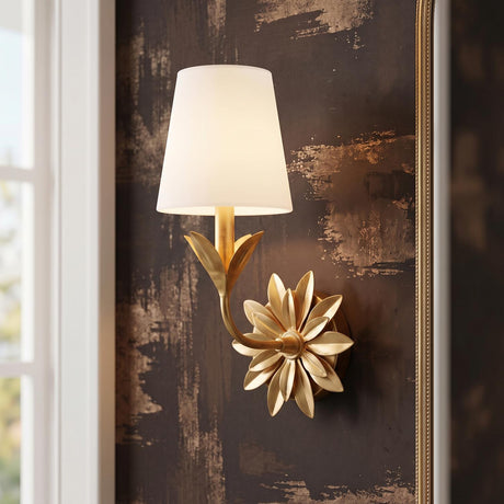 A transitional foyer featuring the Ayla Wall Sconce 15", Antique Gold with a white linen shade mounted on dark textured wallpaper beside a gold framed mirror.