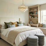 Crystal with Aged Brass geometric tiered Chandelier in a Transitional Bedroom with an upholstered bed and built-in desk.