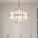 A transitional closet featuring the Maxwell 12 Light Chandelier 22", Crystal with Polished Nickel suspended in front of off-white paneled wardrobe cabinets.