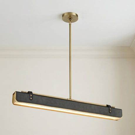 Jarrett LED Linear Pendant 31", Aged Brass and Tuxedo Leather linear pendant in a Contemporary Dining Room with a sleek dining table.