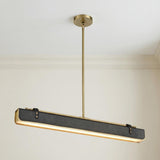 Jarrett LED Linear Pendant 31", Aged Brass and Tuxedo Leather linear pendant in a Contemporary Dining Room with a sleek dining table.