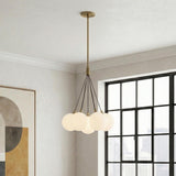 Soren 7 Light Brushed Brass globe Chandelier in a Modern Living Room with a black grid window and geometric art.