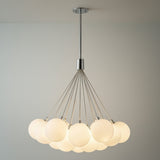 Soren 19 Light LED Chandelier 28", Chrome and Opal Glass globe Chandelier in a Modern Living Room with a minimalist sofa.