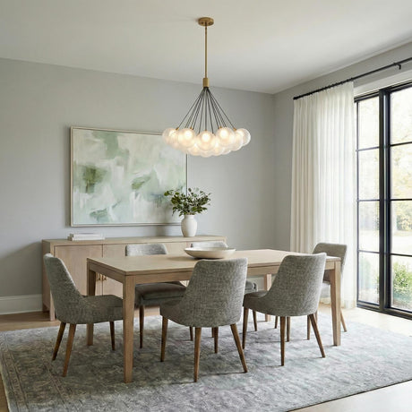 Soren 19 Light LED Chandelier, Brushed Brass and glass globe chandelier in a Contemporary Dining Room with a light wood table and rug.