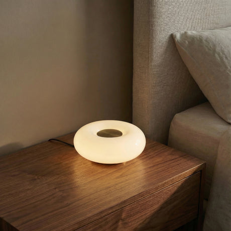 Otto LED Table Lamp 9", Aged Brass and Opal Glass geometric Table Lamp in a Modern Bedroom with a dark wood nightstand.