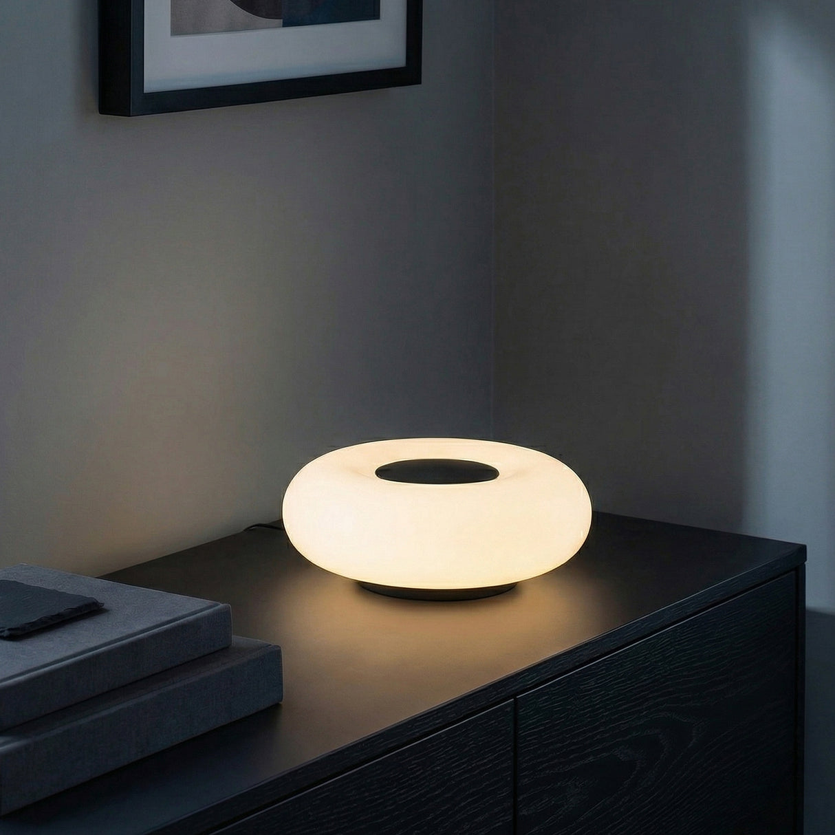 Otto LED Table Lamp 9, Matte Black and Opal Glass, in a Modern Living Room on a dark wood cabinet.