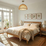 Montauk Pendant 24", Rattan with Opal Glass Brass woven Pendant in a Coastal Bedroom with a light oak bed and jute rug.