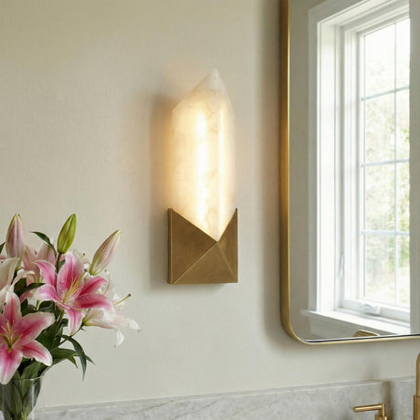 Lunaire 12" Aged Brass and Alabaster geometric Wall Sconce in a Contemporary Bathroom with a marble vanity and pink lilies.