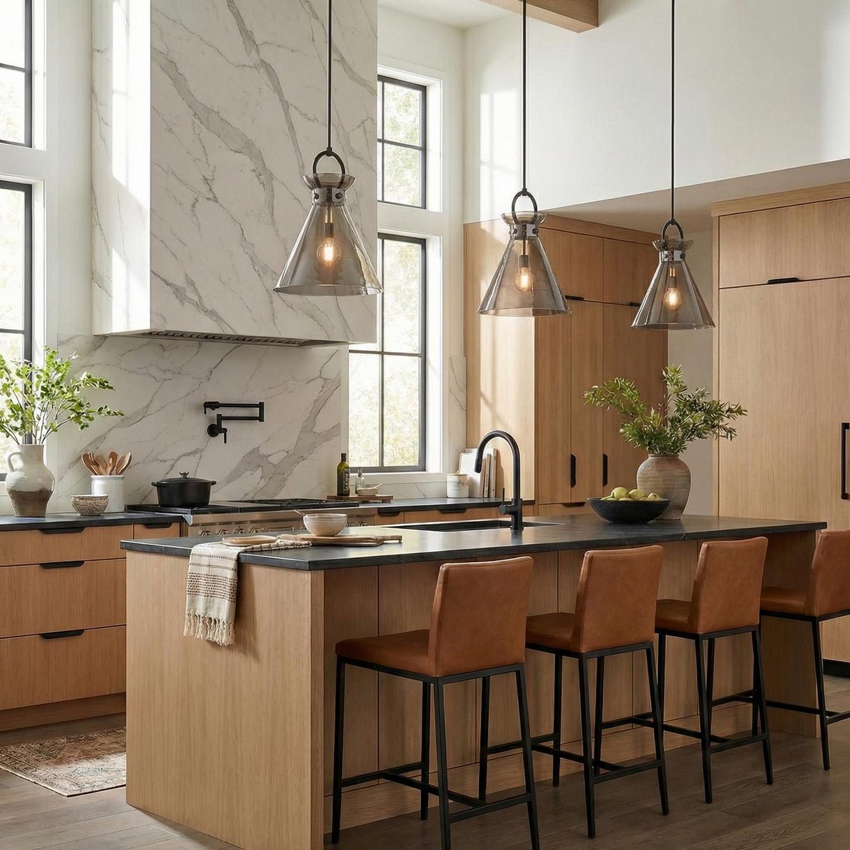 Aris Matte Black and Smoke Glass geometric pendant in a Modern Farmhouse Kitchen with light wood island and leather bar stools.