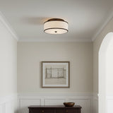 Walker Medium Flush Mount 20" Old Bronze - A drum-shaped flush mount light fixture with a white fabric shade and an old bronze trim is installed on a white ceiling.
