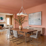 A contemporary dining room with peach walls featuring the Veda 3 Light Chandelier 26 inch in textured white over a walnut table and herringbone floors.